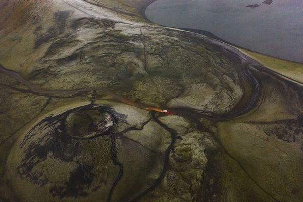 an aerial view of a volcano with a river running through it in the highlands in iceland.