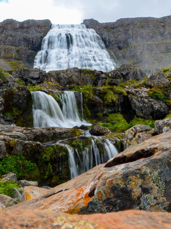 a waterfall is surrounded by rocks in the middle of a mountain dynjandi in iceland.