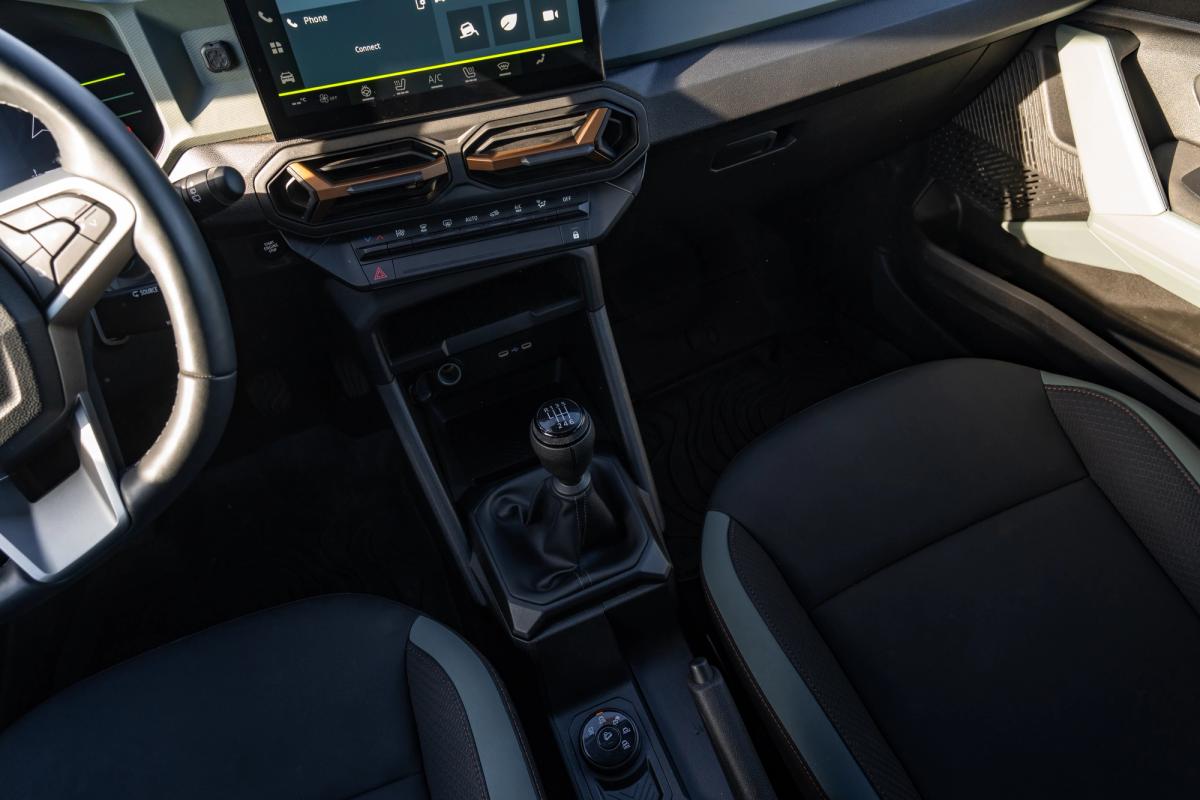 Consola central do Dacia Duster com alavanca de velocidades manual, bancos dianteiros e saídas de ar