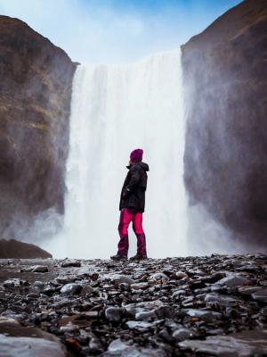 Girl dressing with waterproof jacket and pants, boots, and a hat