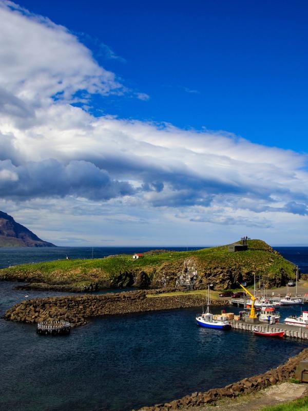una pequeña isla en medio del océano con barcos atracados en el agua.