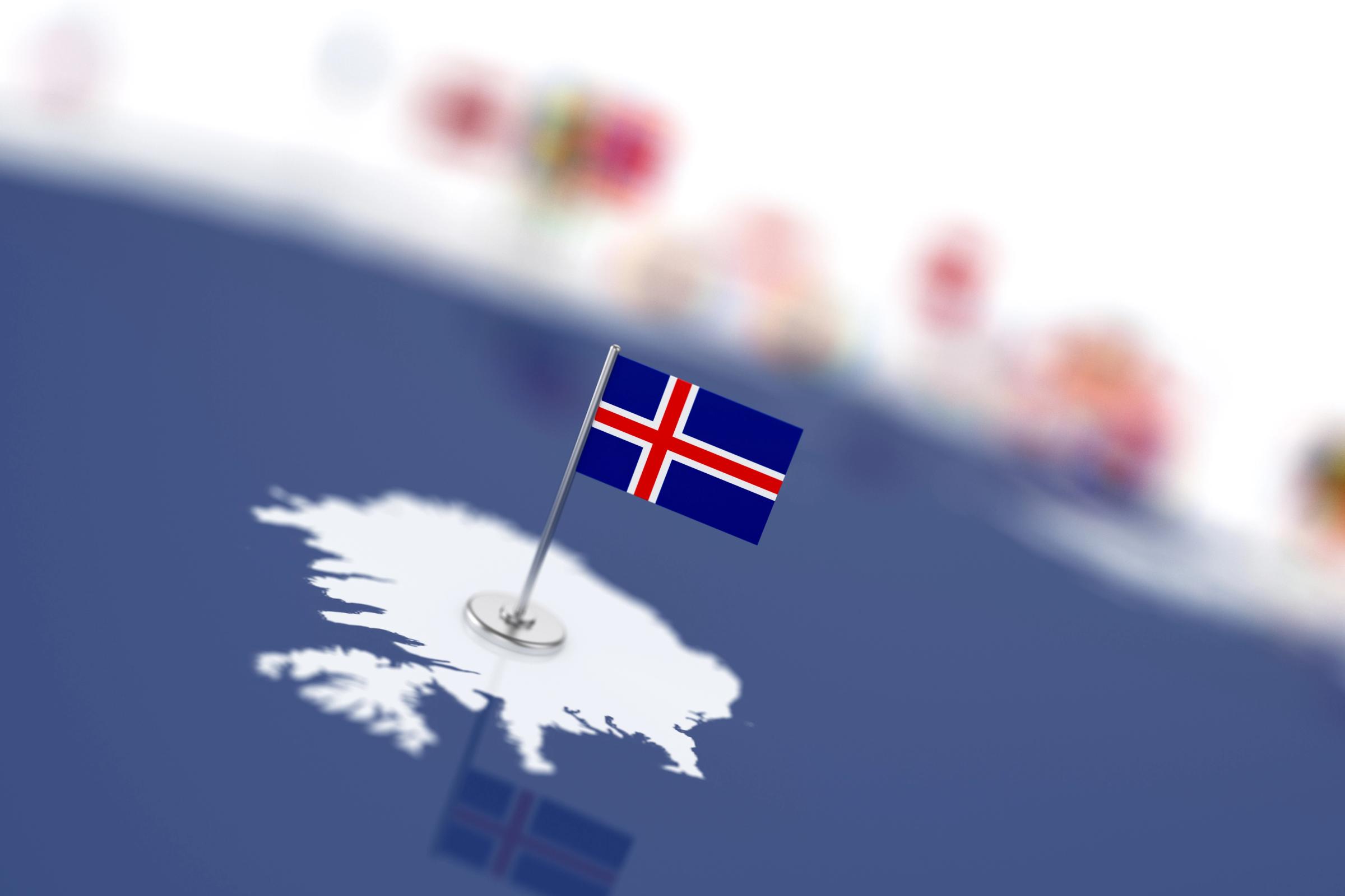 a small flag is pinned to a map of iceland .