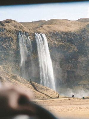 a waterfall is visible through the windshield of a car .