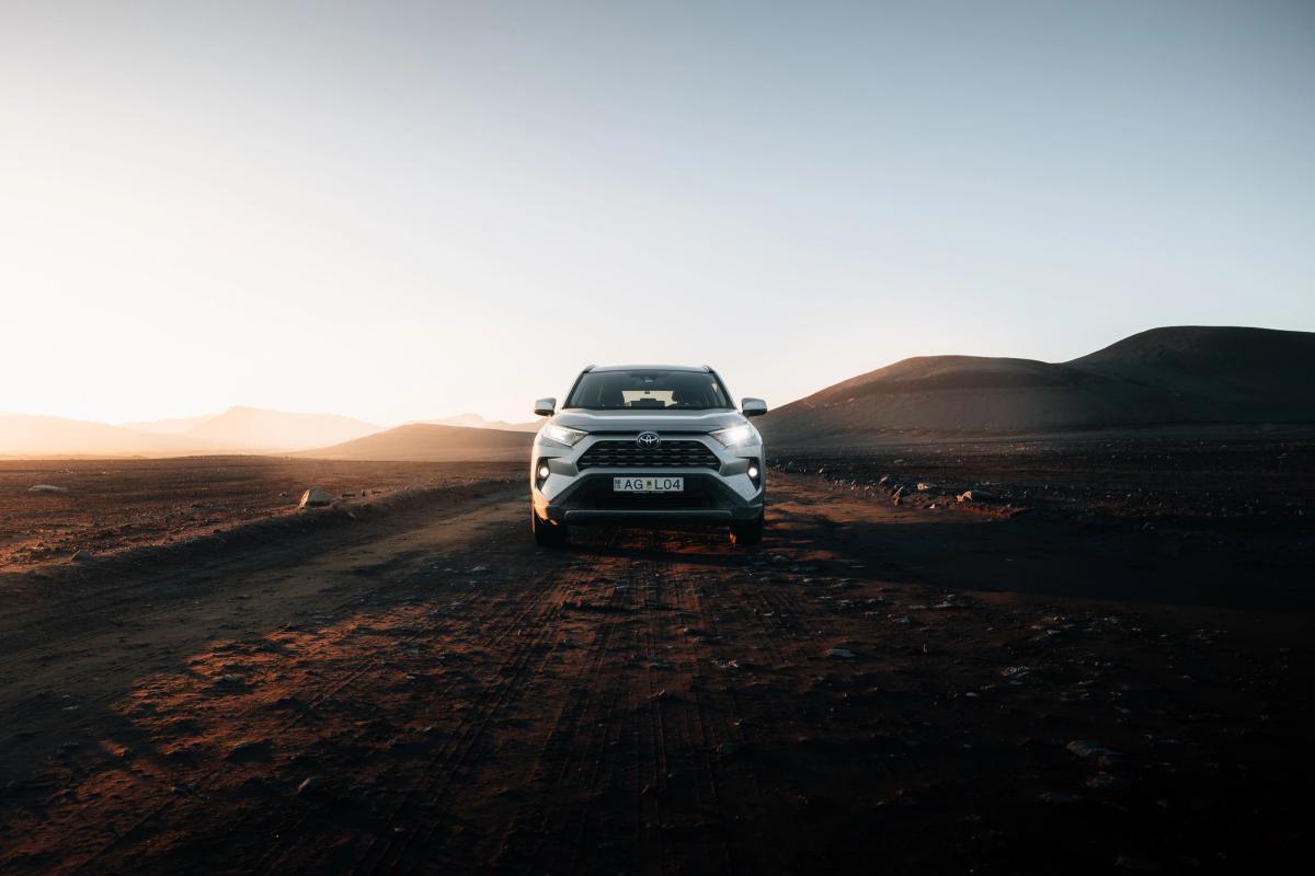 Circuit Highland du RAV4 SUV Toyota RAV4 de location en Islande, vu de face sur une piste de gravier dans un vaste paysage des Hautes Terres