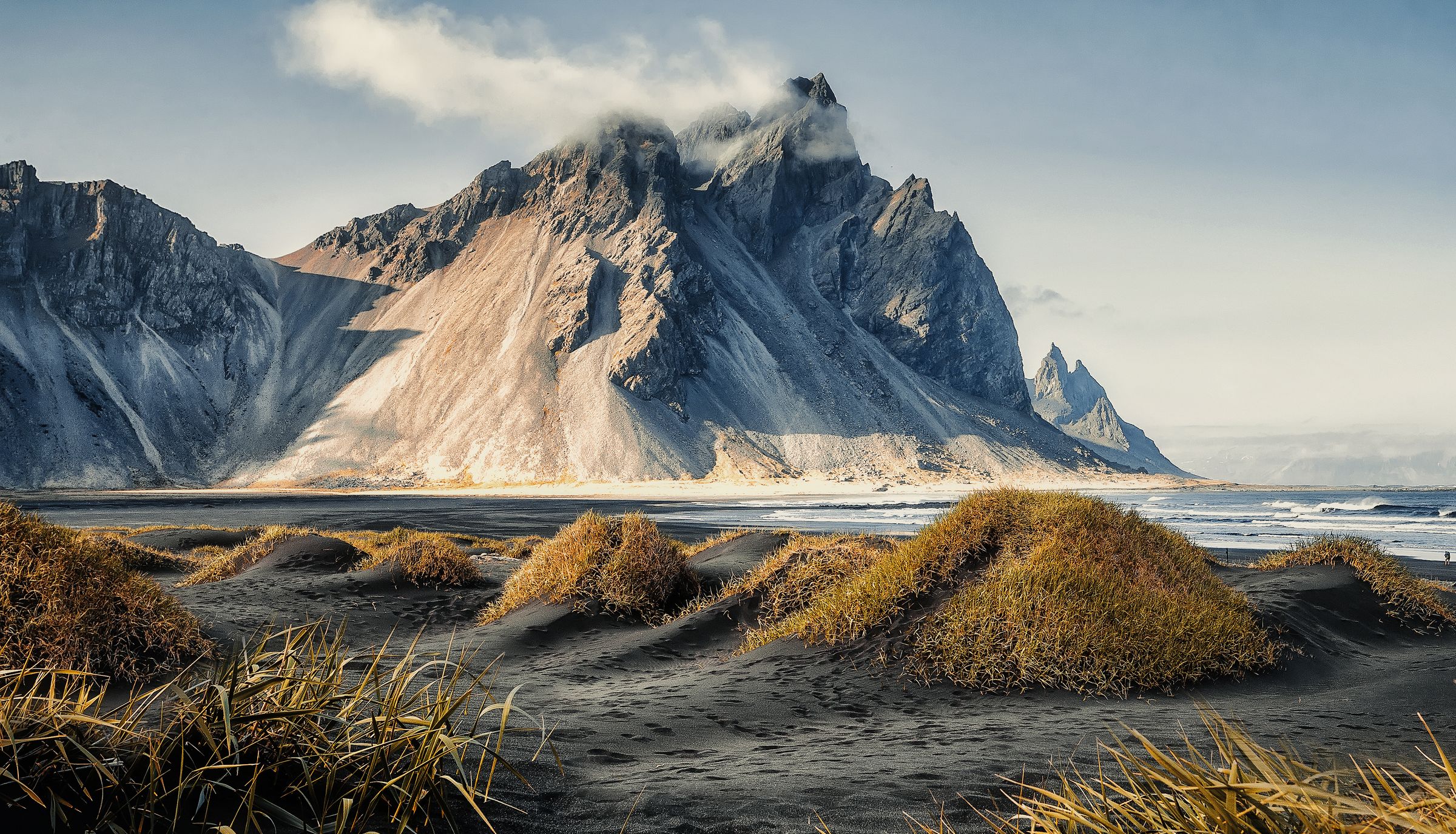 Il y a une montagne en arrière-plan et une plage au premier plan à Vestrahorn à Stokksnes, en Islande.