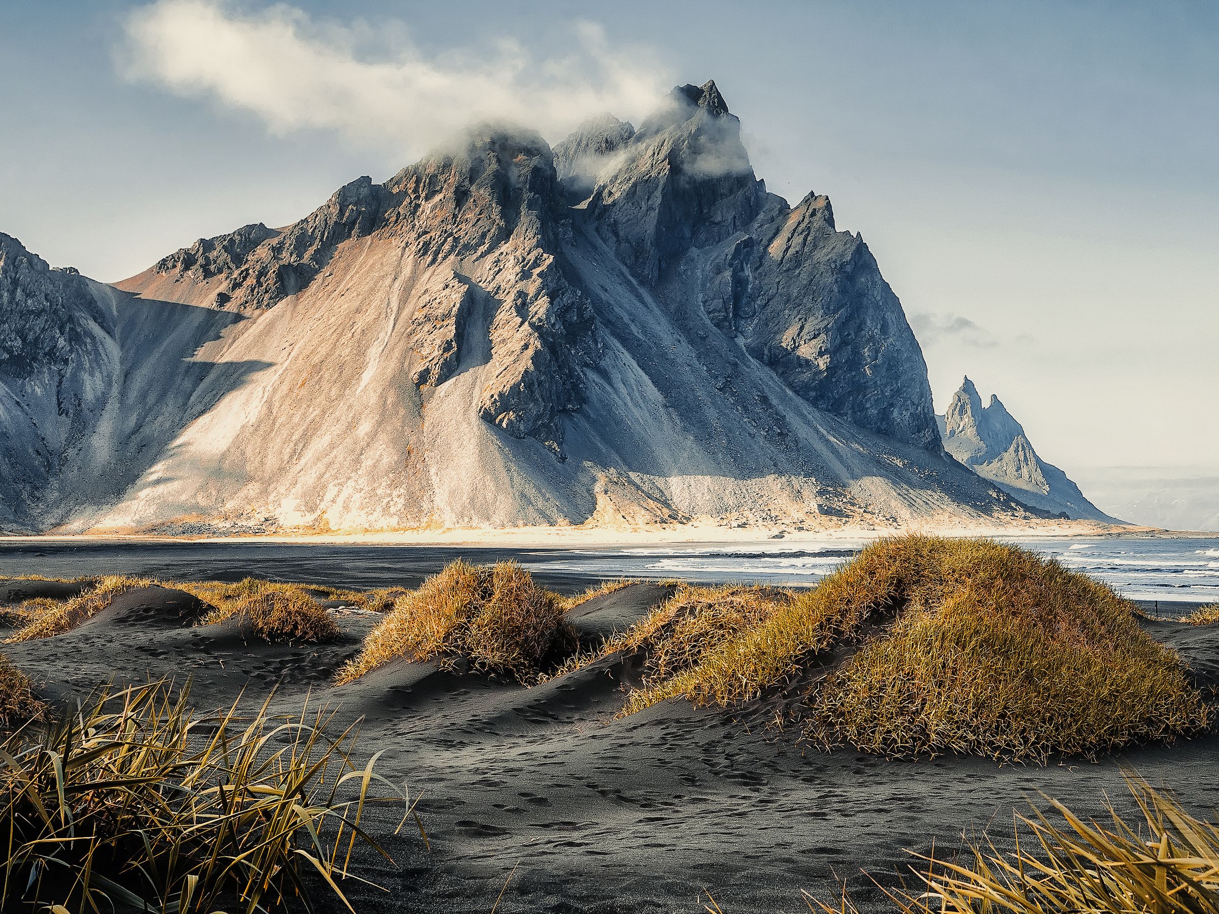 Il y a une montagne en arrière-plan et une plage au premier plan à Vestrahorn à Stokksnes, en Islande.