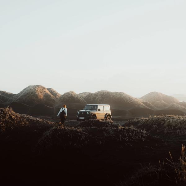 Girl next to a 4x4 car parked in the middle of nature