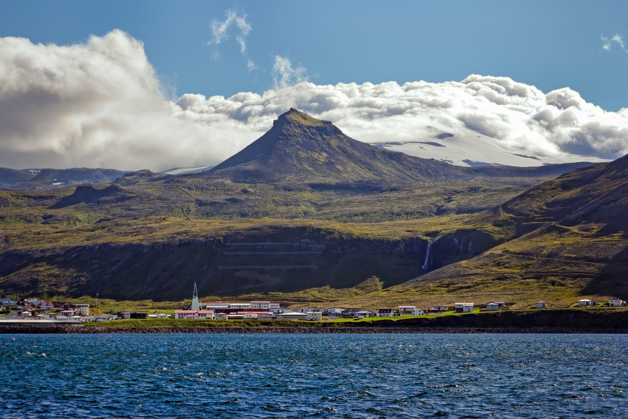 a coastal town with a mountain in the background