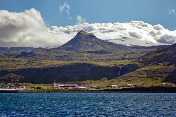 un pueblo pesquero con una montaña al fondo