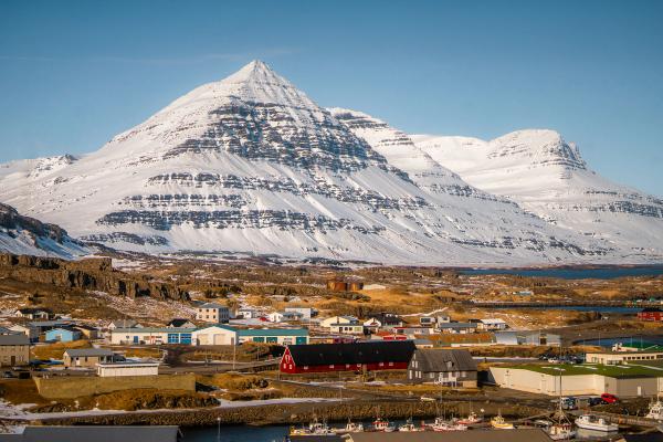 a small town with a large snow covered mountain in the background .