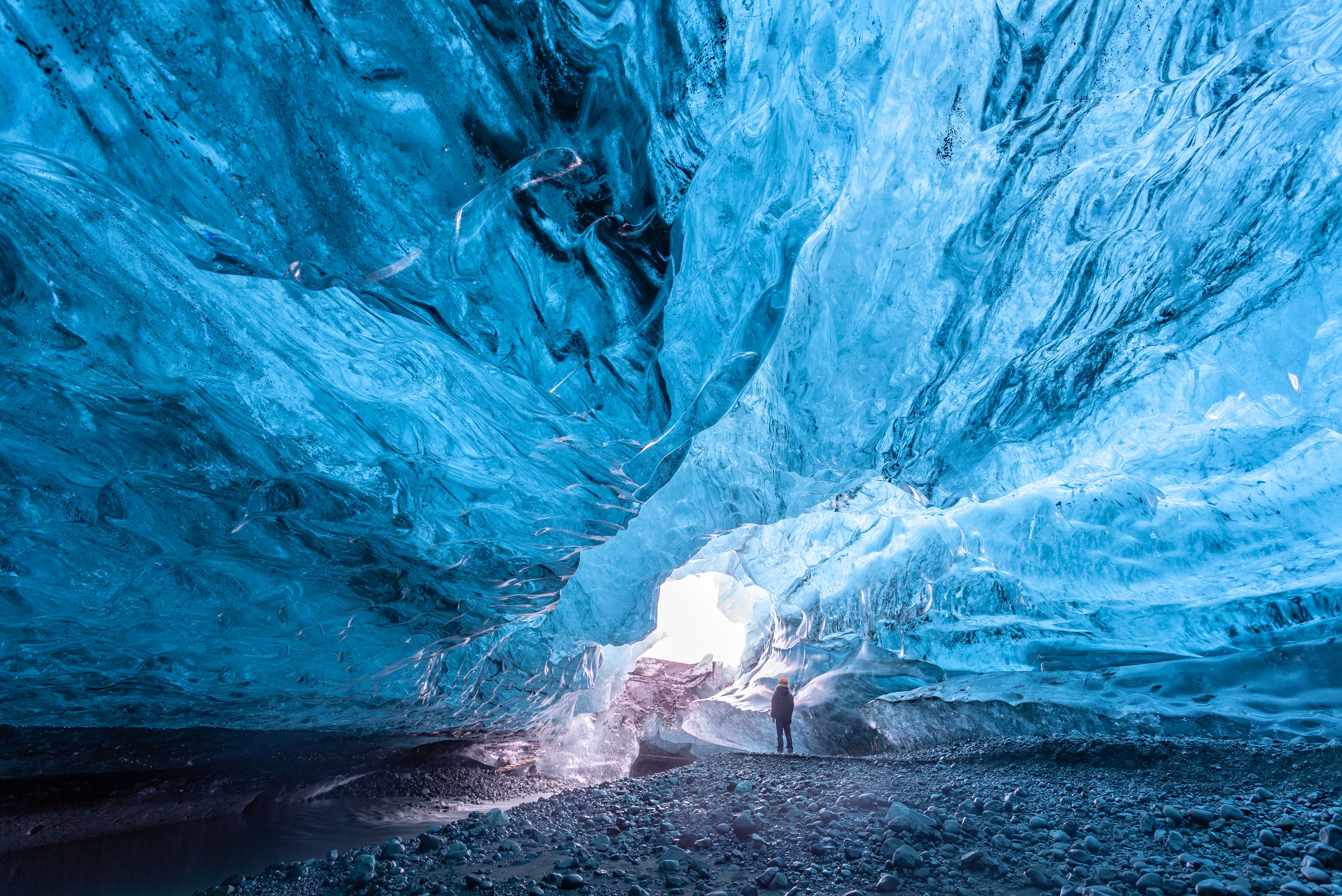 a man is standing inside of an ice cave on a trip in iceland.