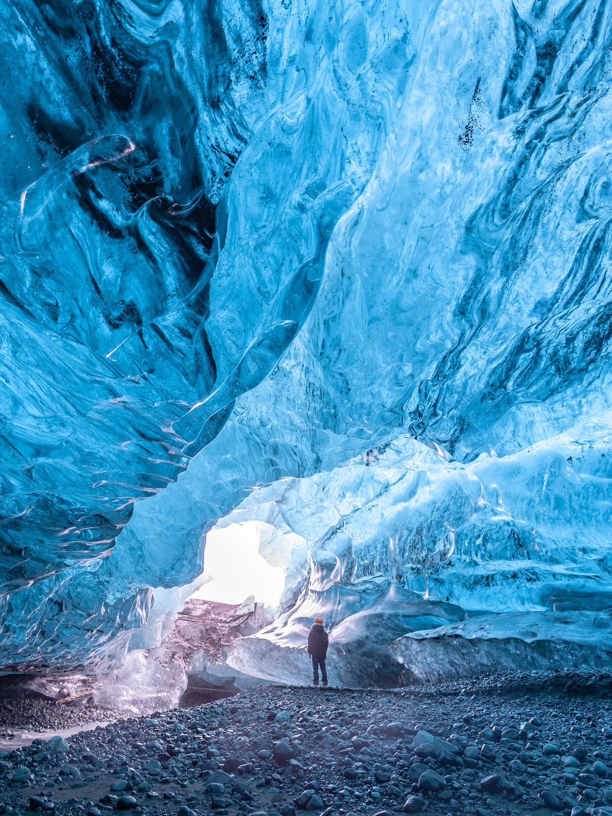 a man is standing inside of an ice cave on a trip in iceland.