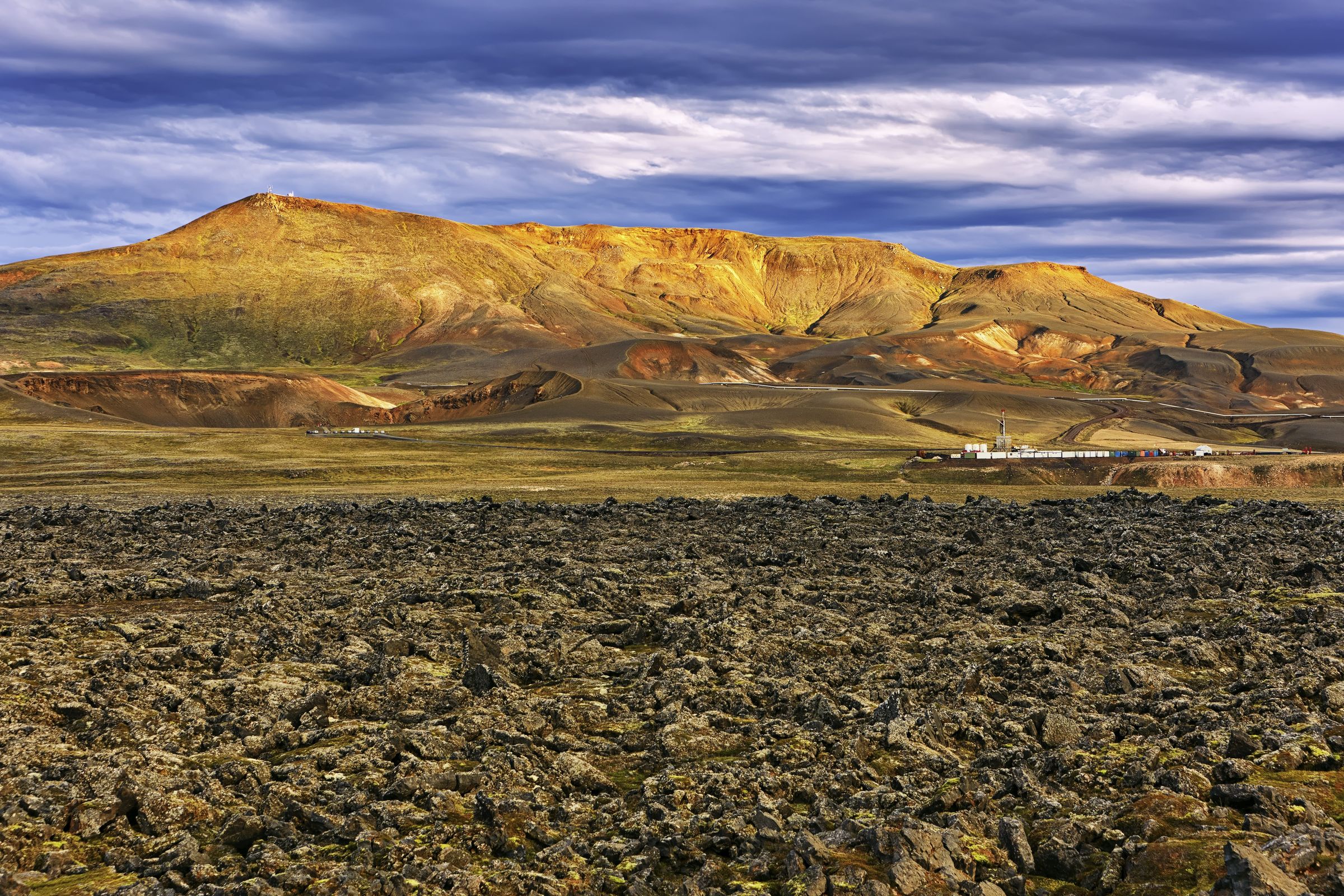 un extenso campo rocoso con una montaña al fondo.