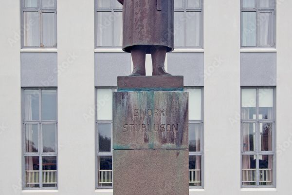 una estatua de un hombre de pie frente a un edificio que dice 'andersson sturloson' en él