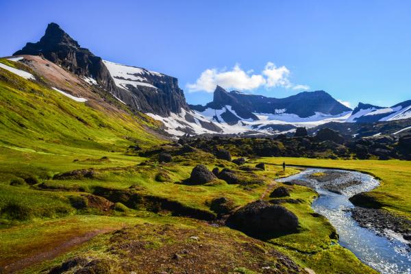 a person is standing on a bridge over a stream in the mountains at stórurð in iceland.