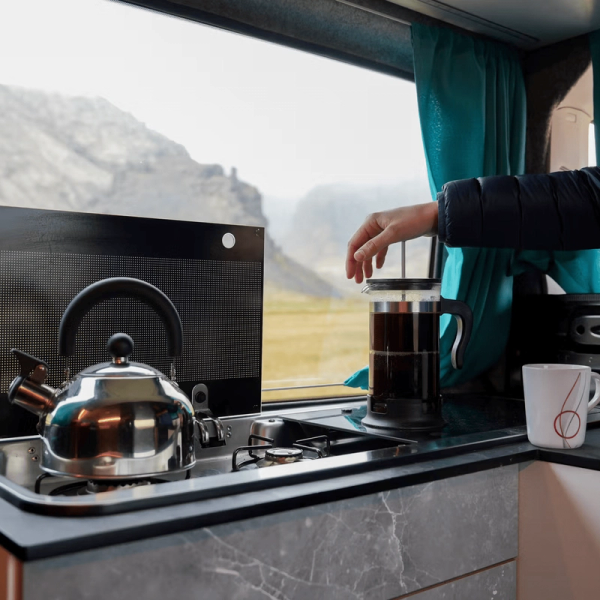 a person is pouring a cup of coffee into a french press