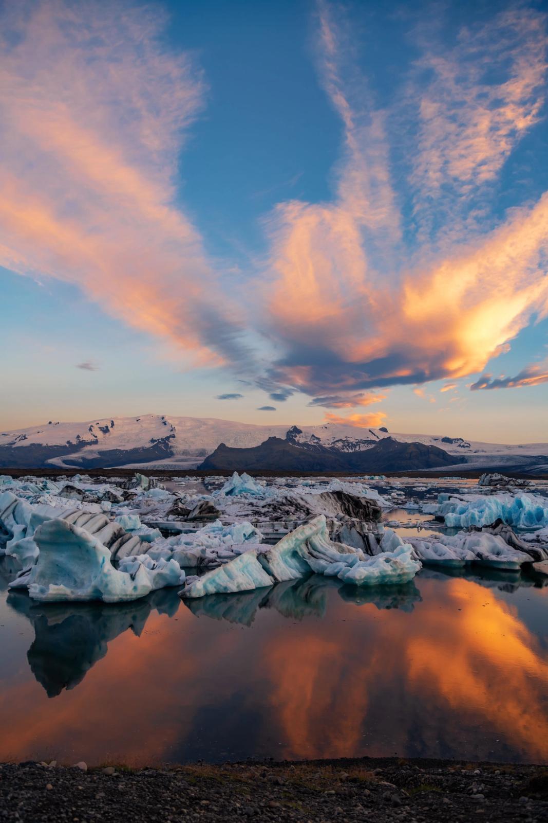 Lagoon with floating icebergs and a golden light reflecting on its waters