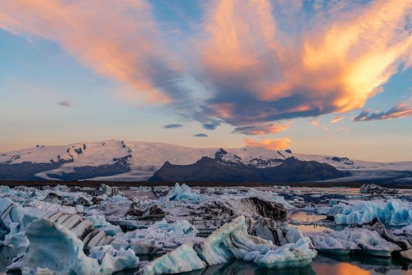 Lagoon with floating icebergs and a golden light reflecting on its waters