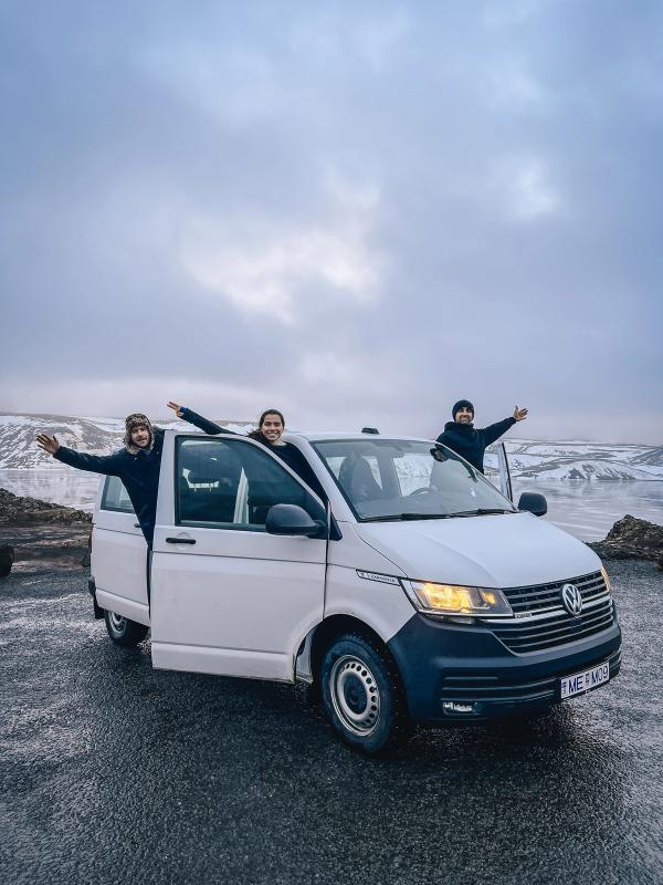 Minivan Rental Car Iceland three people are standing in a white van with their arms outstretched
