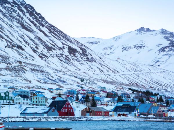 pueblo costero con grandes montañas nevadas al fondo