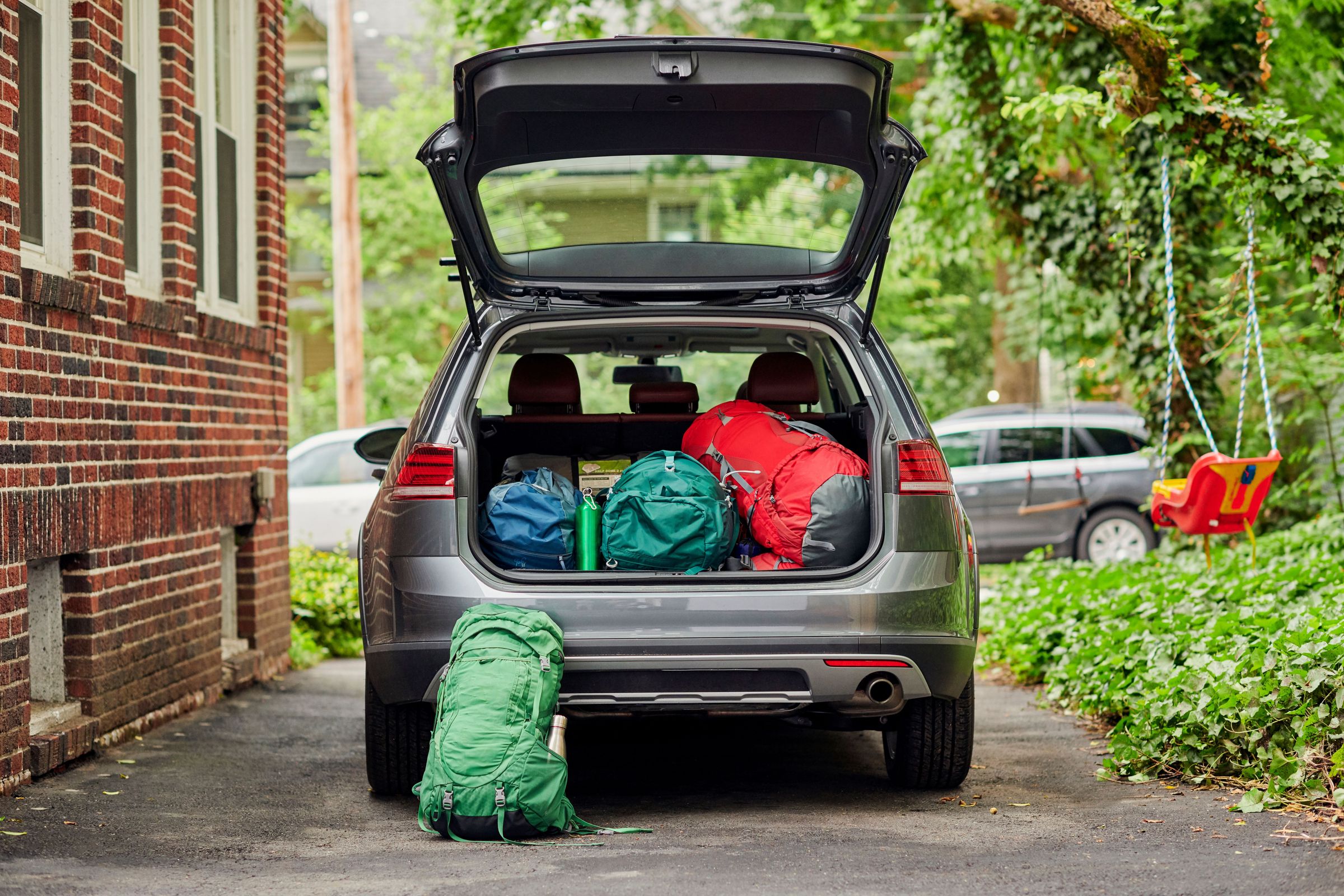 the trunk of a car is filled with backpacks and luggage .
