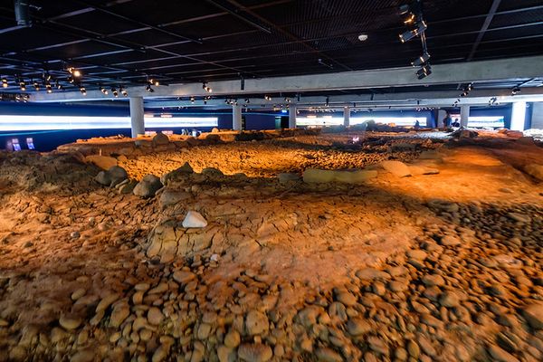 a large room filled with rocks and dirt under a ceiling .