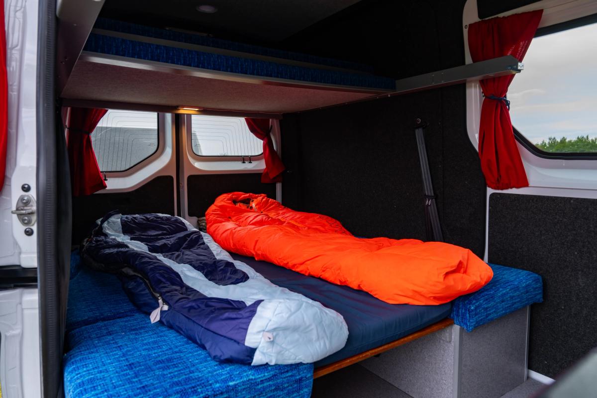Lower bed made up with 2 sleeping bags under the upper bed at the rear
