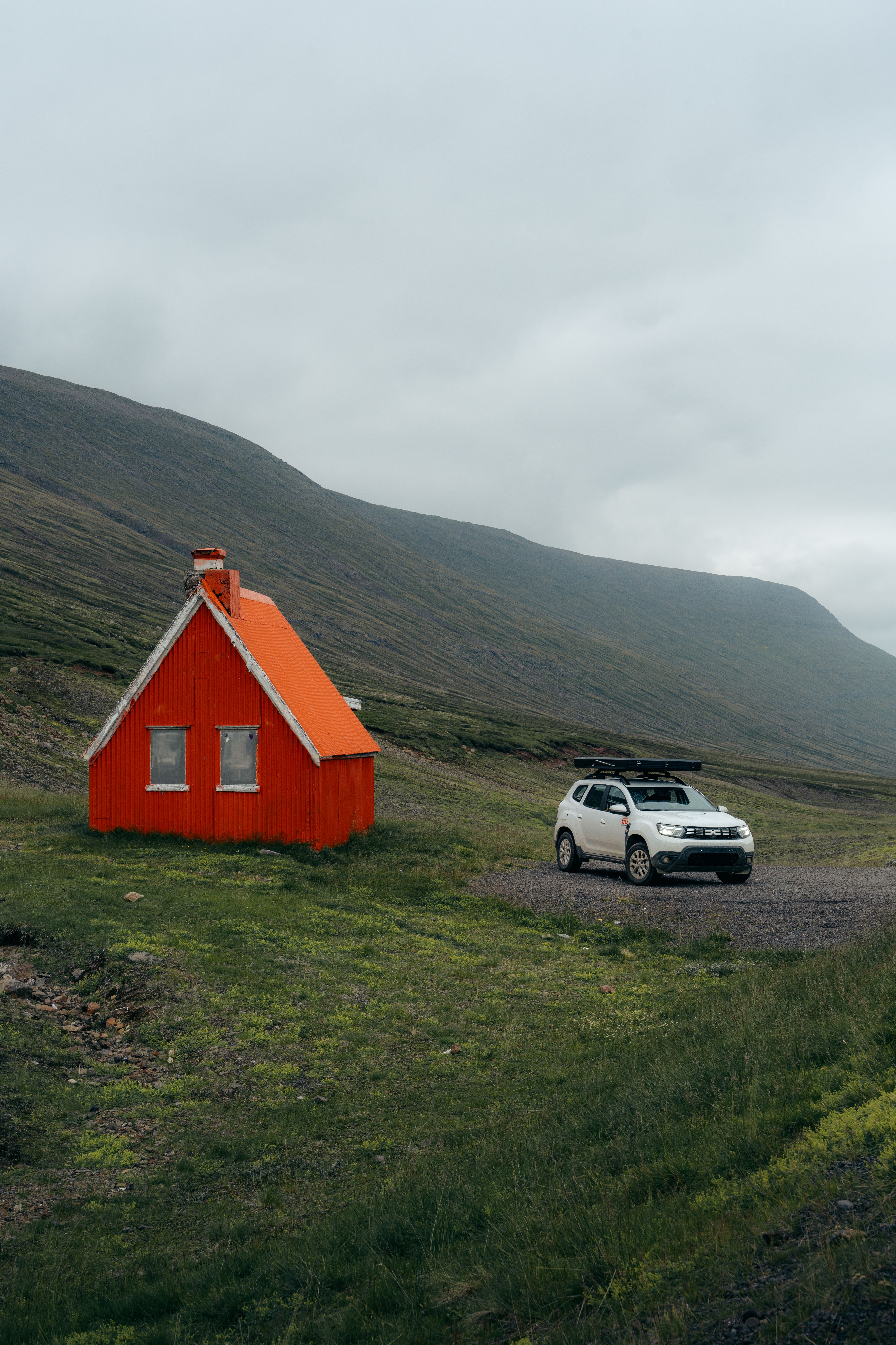 a white car is parked in front of an orange house