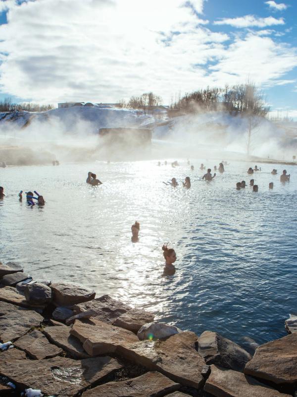 a group of people are swimming in a hot spring .
