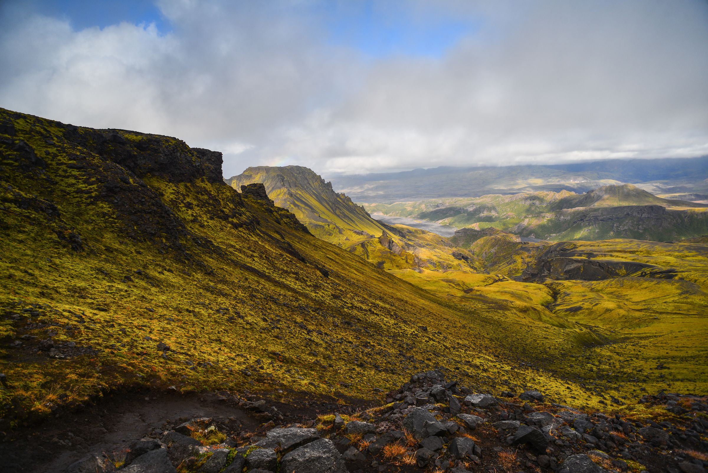 a view of a mountain valley from the top of a hill on a cloudy day, Fimmvörðuháls Hike