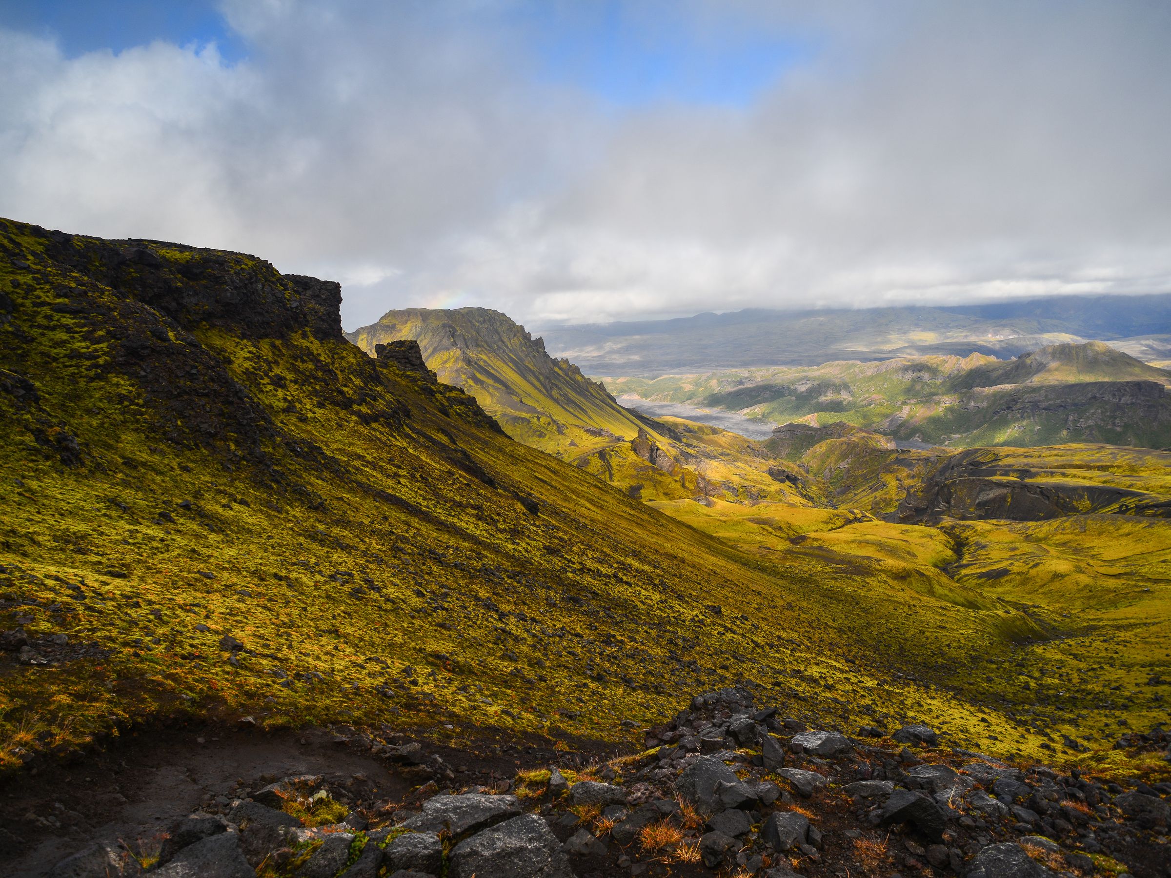 a view of a mountain valley from the top of a hill on a cloudy day, Fimmvörðuháls Hike