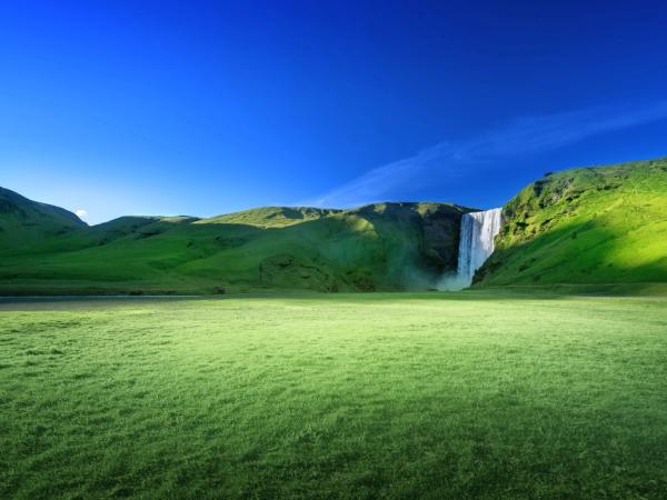 Picture of Skogafoss surrounded by green scenery