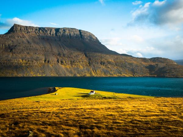 una pequeña isla en medio de un lago con una montaña de fondo .