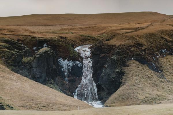 Waterfall surrounded by striking red and black rocks