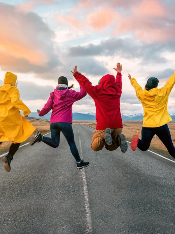 Adventure knows no bounds when shared with friends Four friends jumping in Iceland, expressing pure happiness