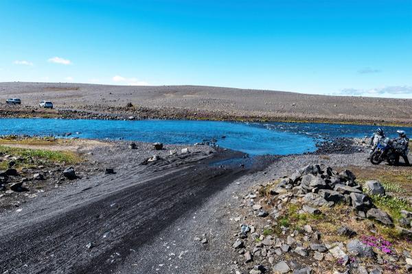 F910 – Dyngjufjallaleið in Iceland Two motorbike tourists thinking how to cross the river to continue F910 road in Central Highlands of Iceland