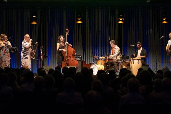 a group of people are playing instruments on a stage in front of a crowd .