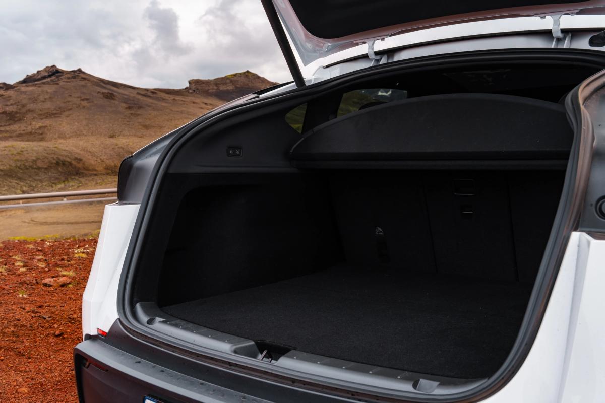 Tesla Model Y con el maletero trasero abierto y montañas de fondo, un espacioso SUV eléctrico de alquiler en Islandia