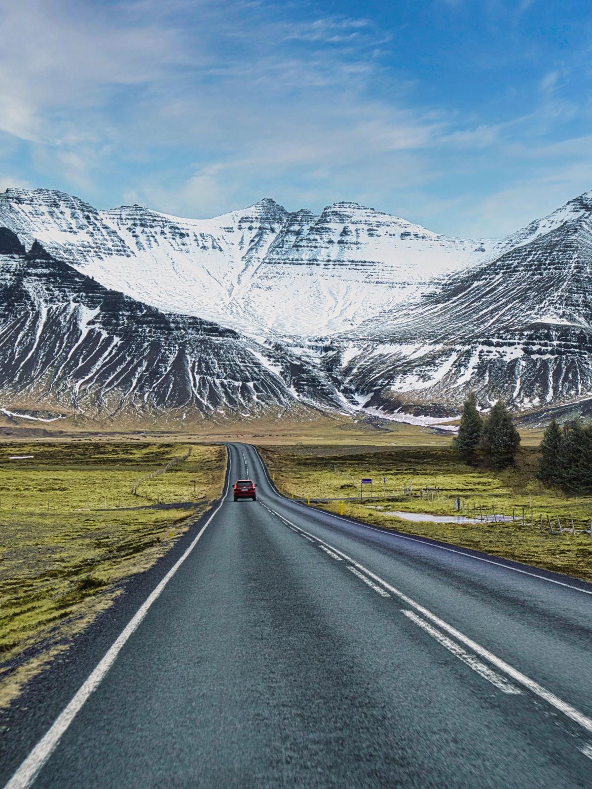 Car driving towards snowy mountains in Iceland