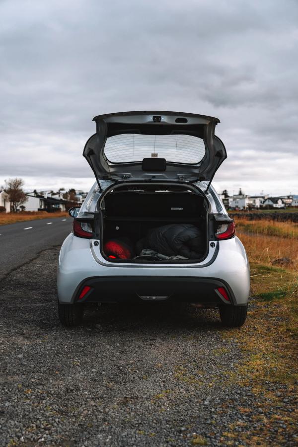 Toyota Yaris open trunk view with luggage parked on a gravel road