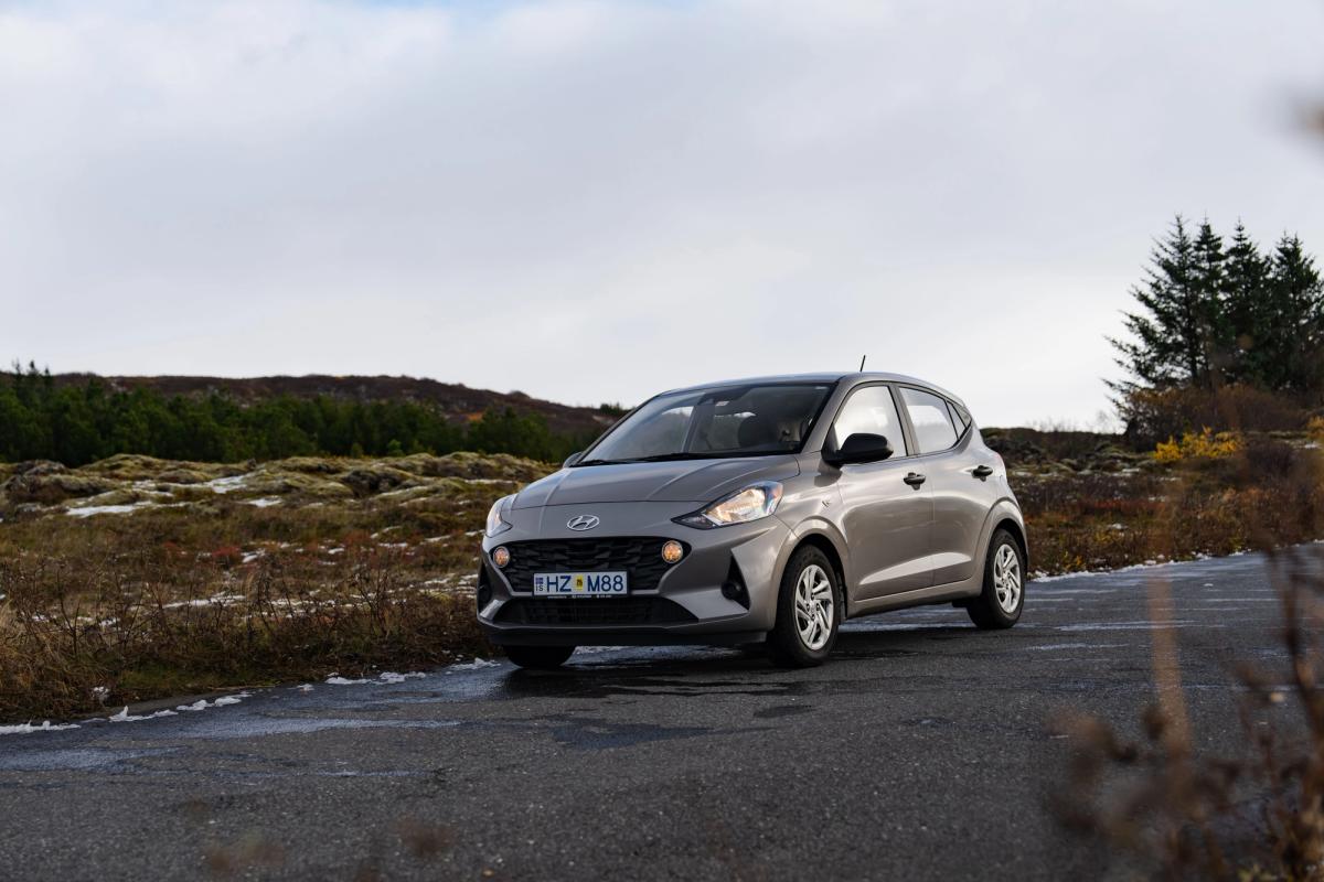 Frontansicht eines Hyundai i10 Kleinwagens, der auf einer asphaltierten Straße in offener Landschaft geparkt ist
