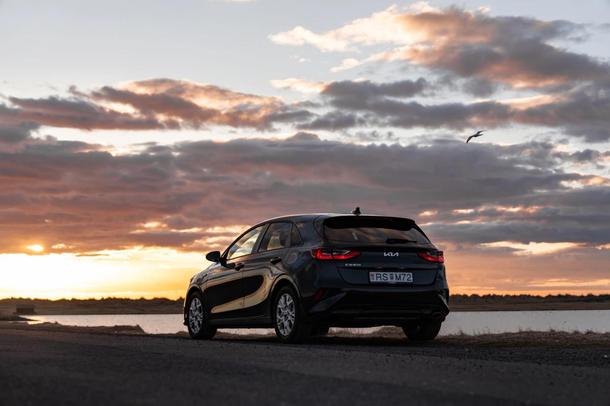 Kia Ceed rear three quarter view on gravel road with dramatic sky