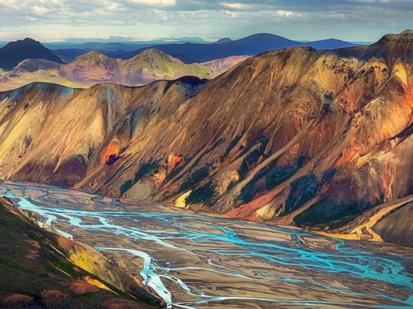 a river running through a mountain valley surrounded by mountains .