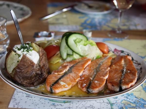 a plate with salmon vegetables and a baked potato