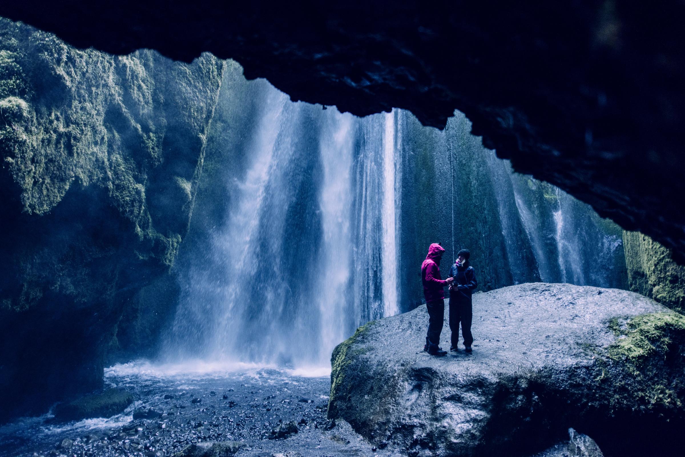 Couple dans une crique avec une chute d'eau
