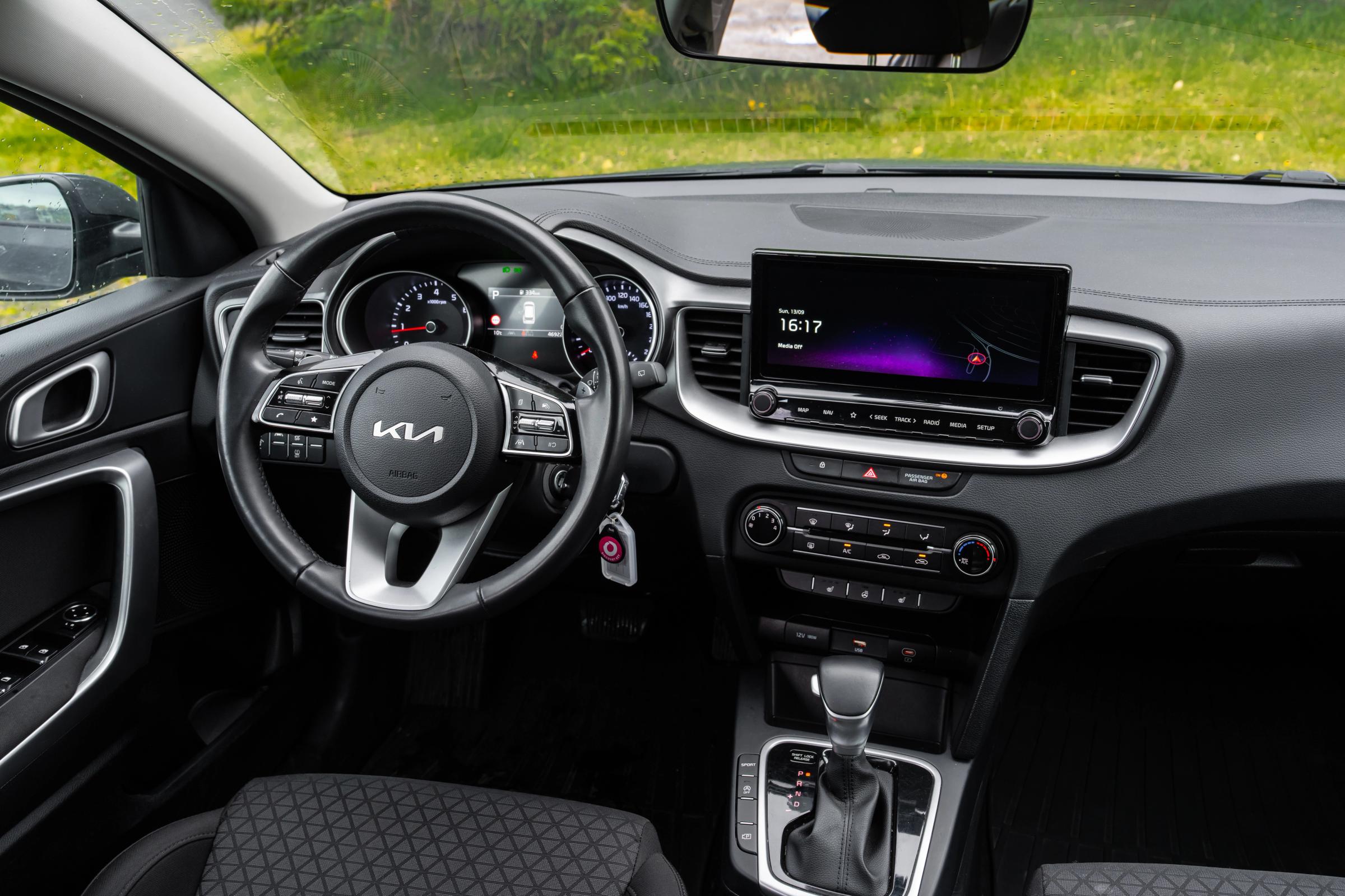 Vista interior del Kia Ceed familiar con volante y sistema de infoentretenimiento con pantalla táctil