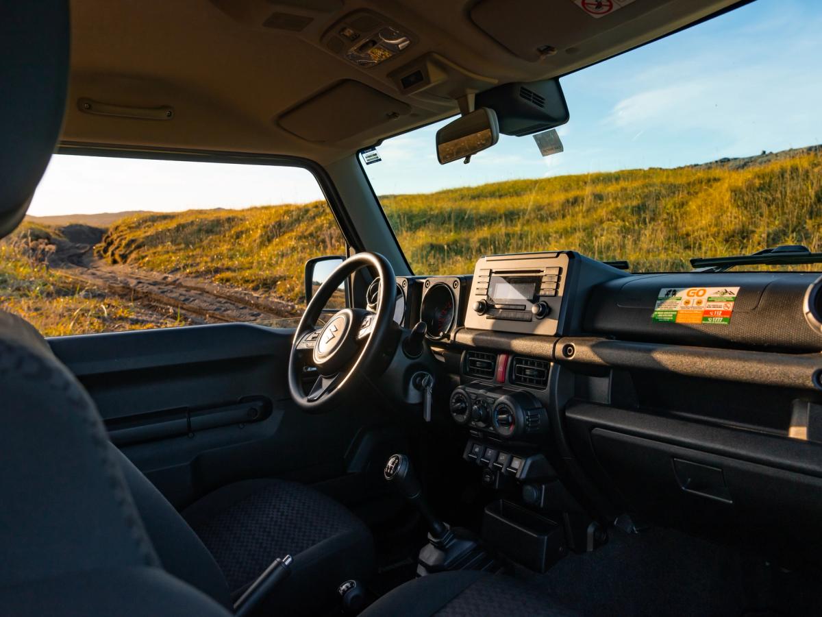 Jimny-Armaturenbrettansicht Armaturenbrett eines Suzuki Jimny mit Schaltgetriebe, Lenkrad und Radio, vom Rücksitz aus gesehen