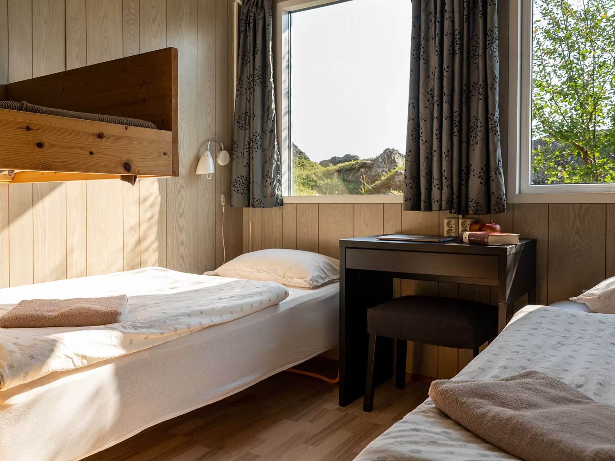 un dormitorio con dos literas, un escritorio y una ventana.
