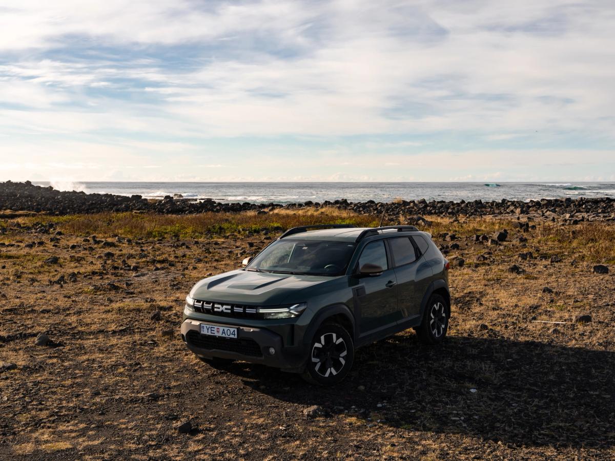 Duster Open Shoreline Vista dianteira a três quartos de um Dacia Duster estacionado num terreno rochoso aberto junto à costa
