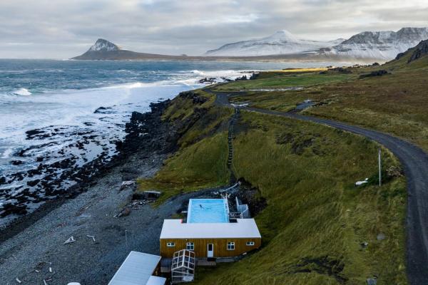 an aerial view of a house on a cliff overlooking the ocean .
